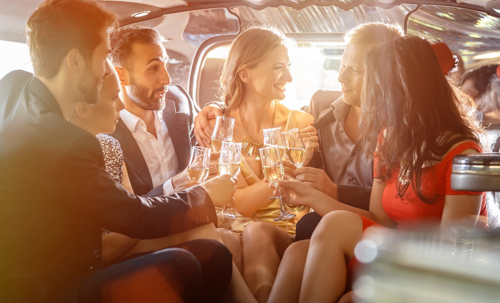 wedding guests celebrating in limo with champagne