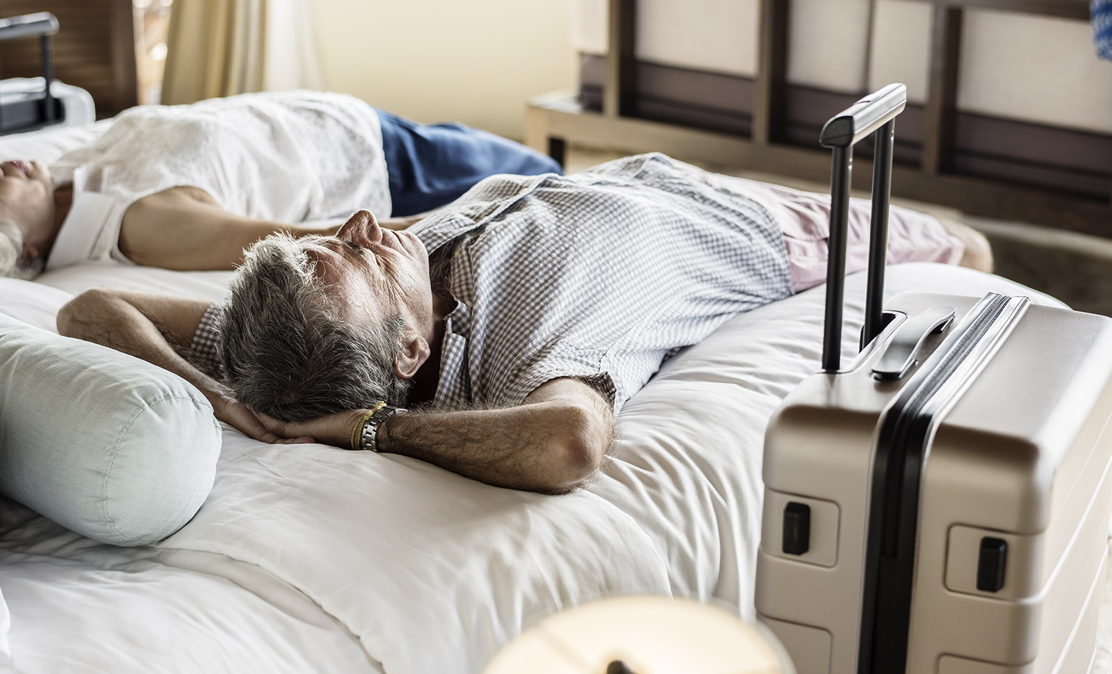 elderly couple relaxing on hotel bed