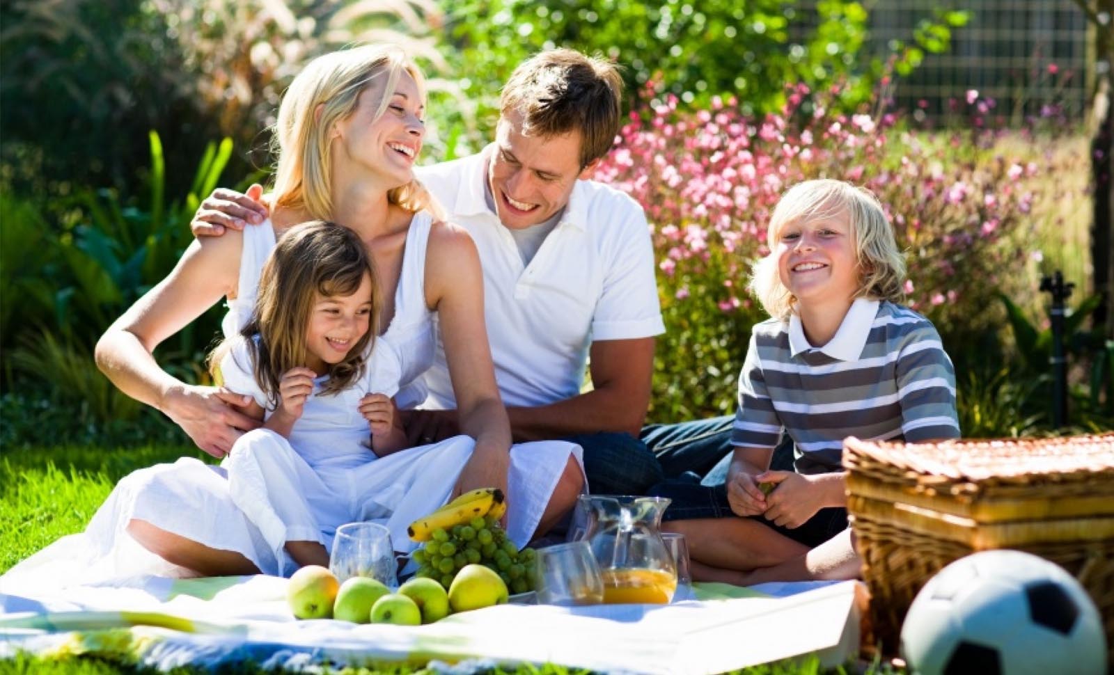 Smiling mother father son and daughter having a picnic in a park